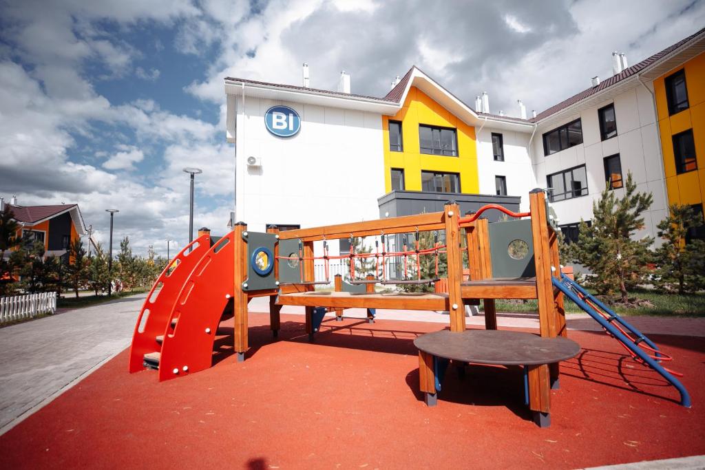 une aire de jeux avec toboggan en face d'un bâtiment dans l'établissement Promenad Burabay 45P, à Borovoe