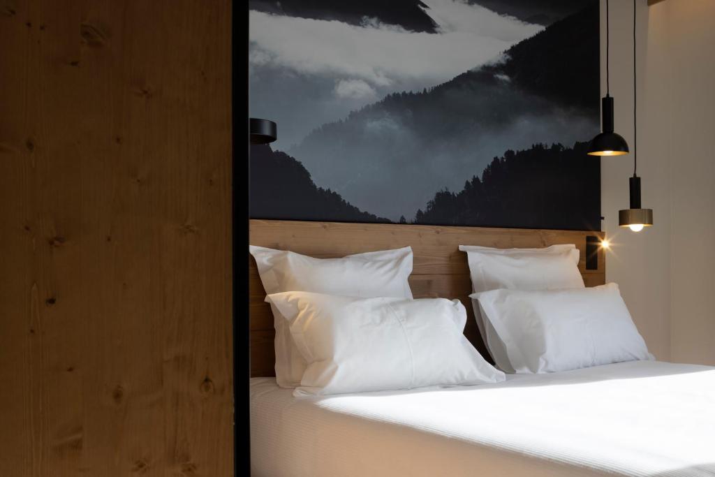 a bedroom with two beds with white pillows at HIGALIK HOTEL in Les Menuires