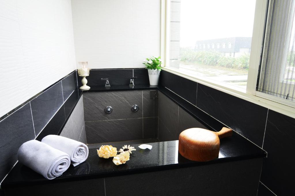 a bathroom with a black counter with towels and a window at Yunju House in Jiaoxi