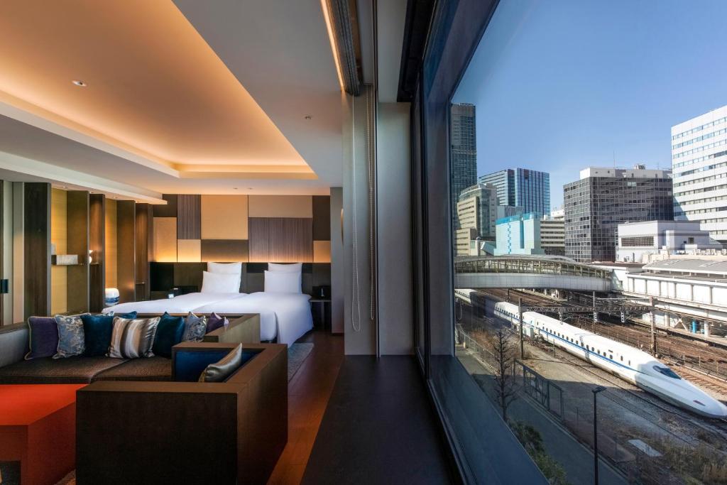 ein Hotelzimmer mit einem Bett und einem großen Fenster in der Unterkunft Pullman Tokyo Tamachi in Tokio