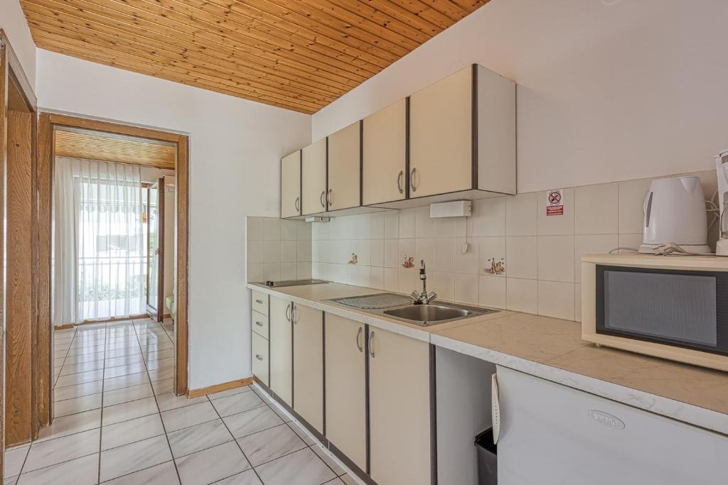 kuchnia z białymi szafkami i zlewem w obiekcie Apartments Kiki Spada w Poreču