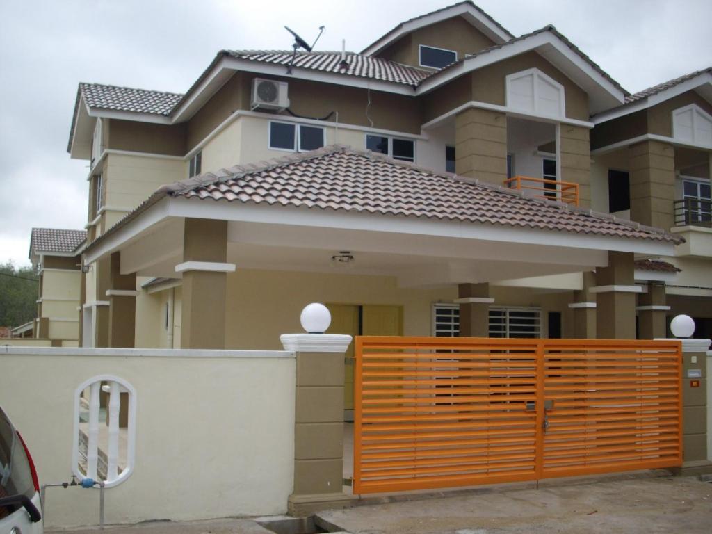una casa con una puerta naranja delante de ella en Greenleaf Angsana Homestay, en Jerantut