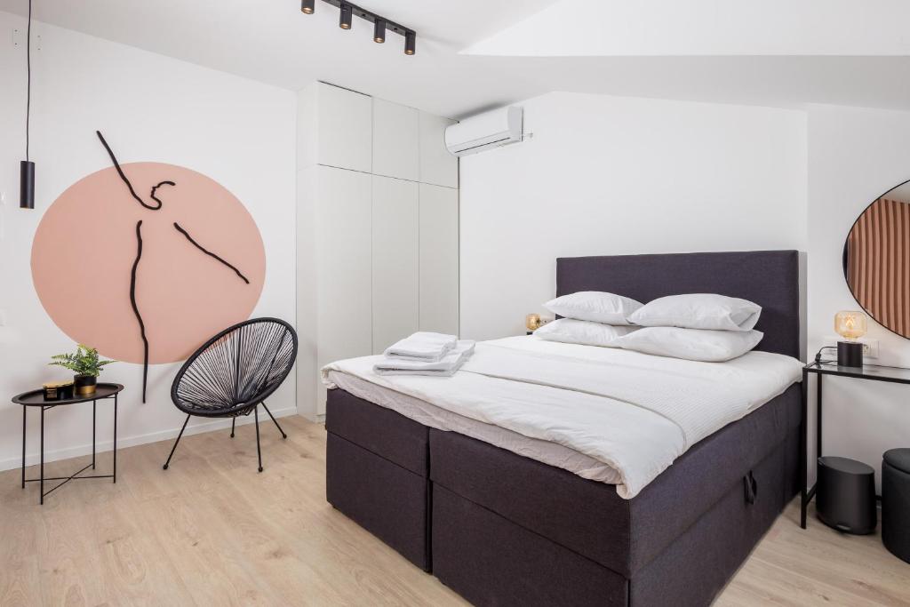 a bedroom with a large bed and a chair at Apartment Pearl, Opatija center in Opatija