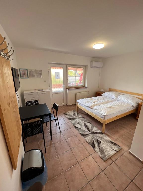 - une chambre avec un lit, une table et un bureau dans l'établissement Simple Apartman, à Siófok