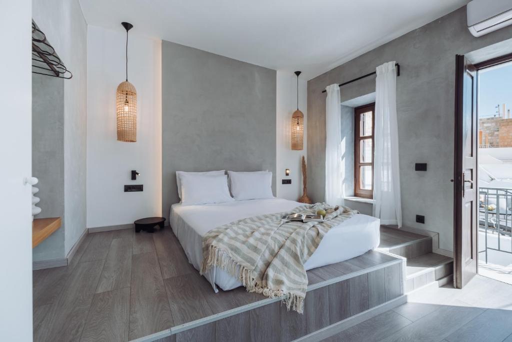 a bedroom with a large bed and a window at Kilistra Lindian Living in Lindos