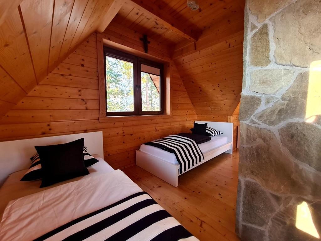 Habitación con 2 camas en una cabaña de madera en Domek w Brzezowej 