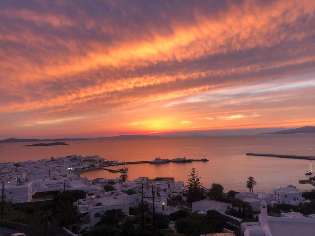 a sunset over a city with a harbor at The Best Town View in Mýkonos City