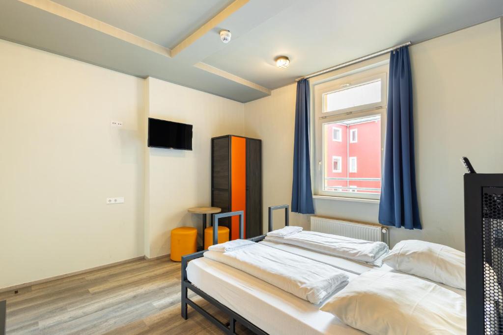 a bedroom with two beds and a window at a&o Dortmund Hauptbahnhof in Dortmund