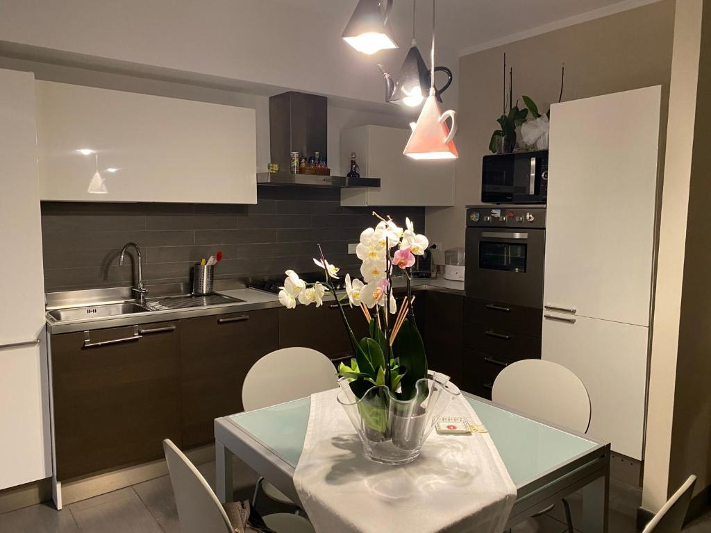 eine Küche mit einem Tisch und einer Blumenvase darauf in der Unterkunft Zia Sara in Pietrasanta
