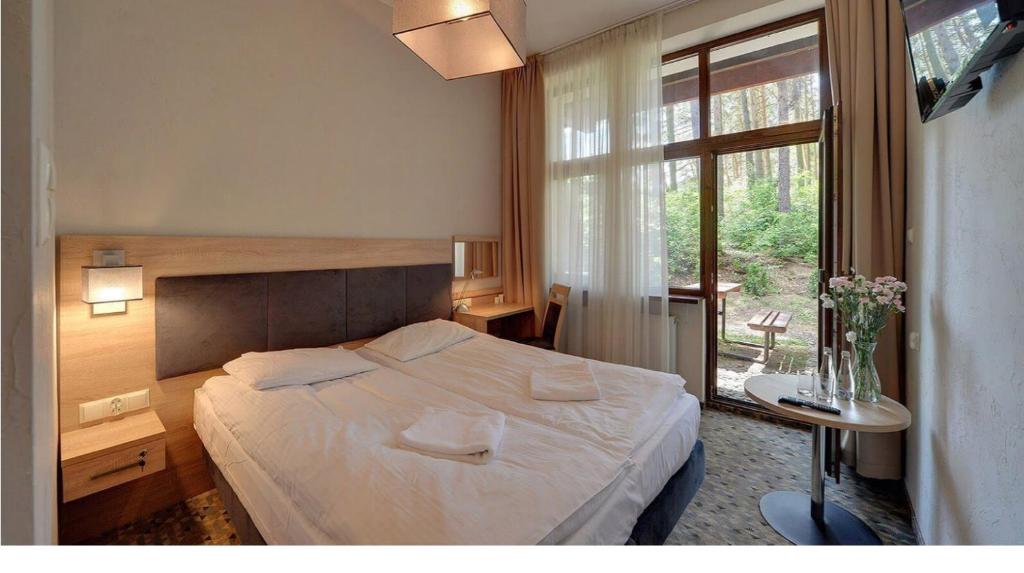 um quarto com uma cama branca e uma janela em Centrum Trzy Jeziora Wieleń em Wielen Zaobrzanski