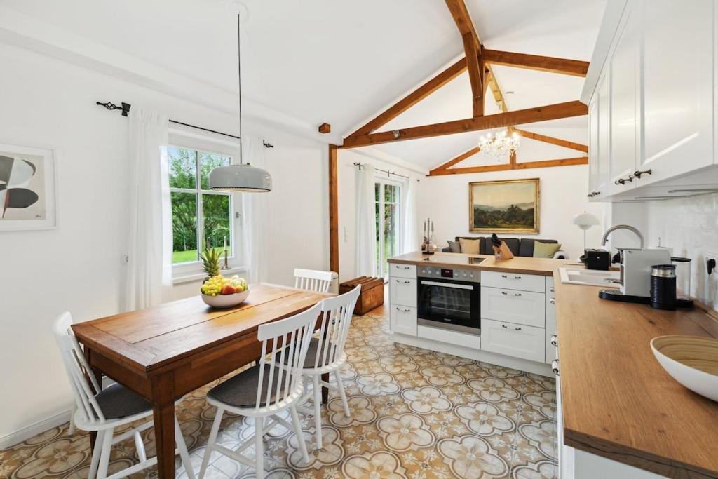 eine Küche und ein Esszimmer mit einem Holztisch und Stühlen in der Unterkunft Idylisches Cottage mit Reh in Wörthsee