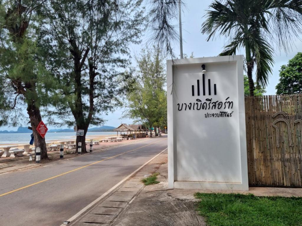una señal en el lado de una carretera junto a una playa en Bangburd Resort, en Ban Khiam En