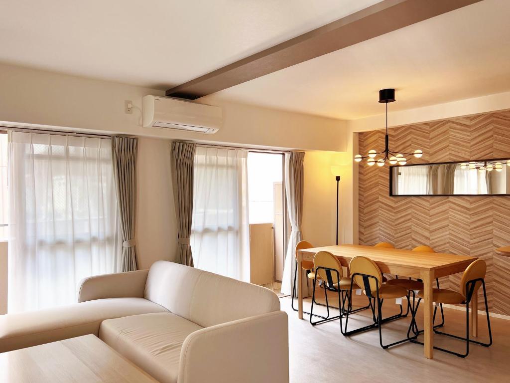 a living room with a white couch and a table at Dio Higashi Shinsaibashi in Osaka