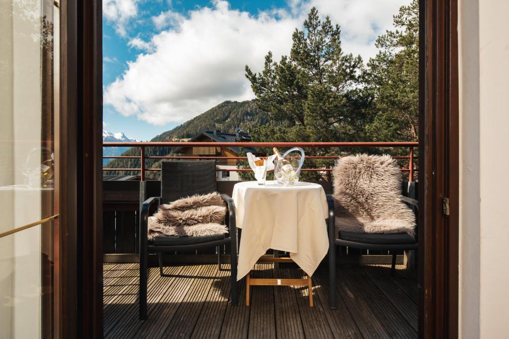 a table and chairs on a balcony with a view at Hotel Garni Alpenruh-Micheluzzi in Serfaus