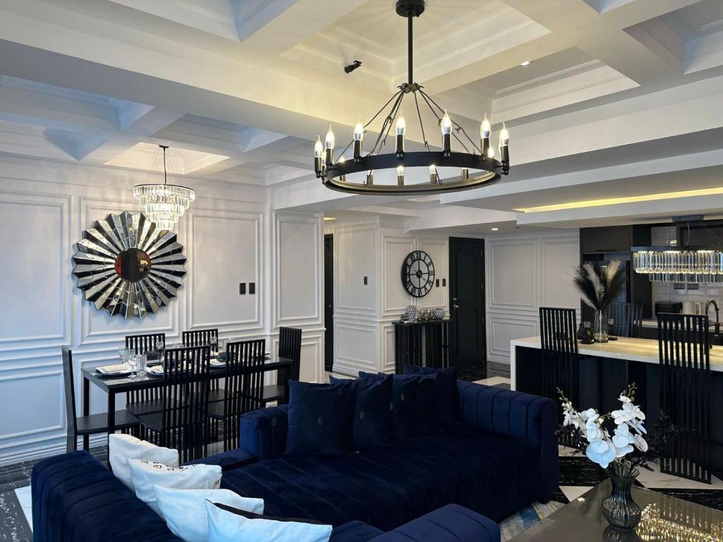 uma sala de estar com um sofá azul e uma mesa em MAKATI Prime Luxury em Manila