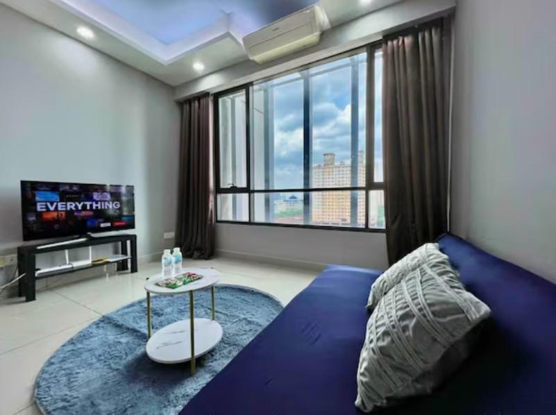 a bedroom with a blue bed and a large window at One Room Studio with WiFi and MRT in Seri Kembangan