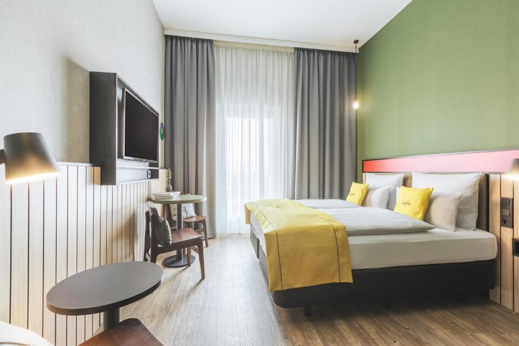 a hotel room with a bed and a table at acora Potsdam Living the City - Apartments in Potsdam