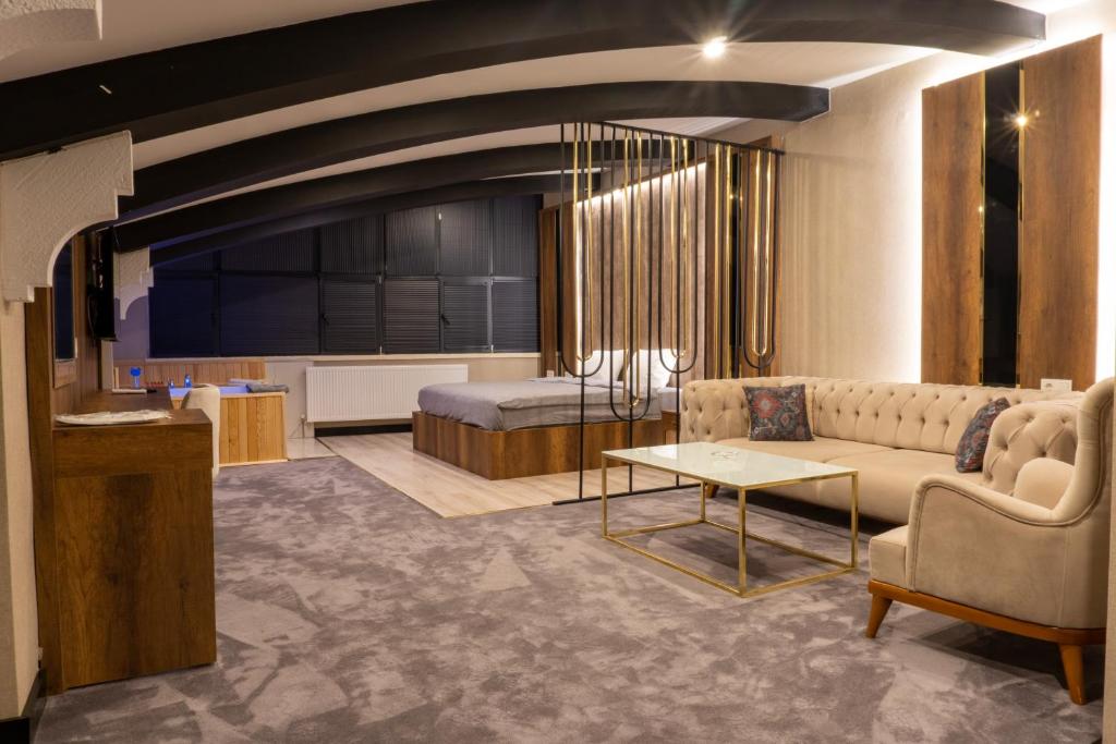 Anatolia Luxury Hotel في Bakanlıklar: غرفة معيشة مع أريكة وسرير