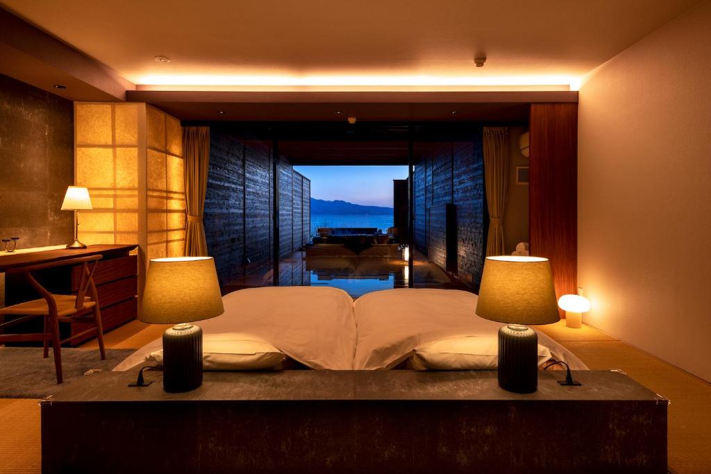 太良町にある太良嶽温泉 蟹御殿のベッドルーム1室(大型ベッド1台、ランプ2つ付)