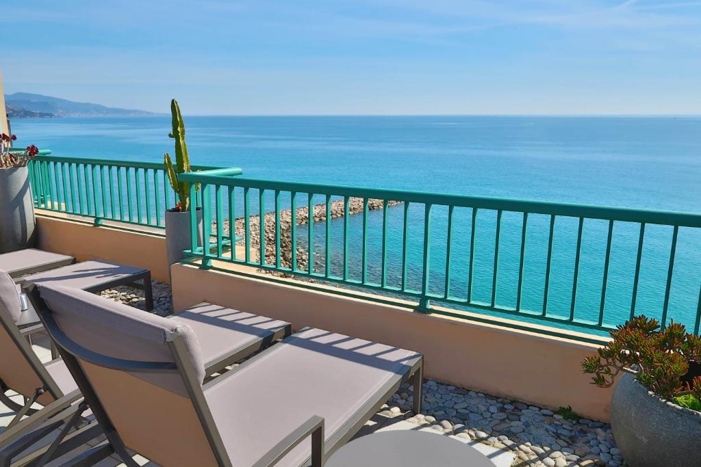 a balcony with chairs and a view of the ocean at Princess Et Richmond in Menton