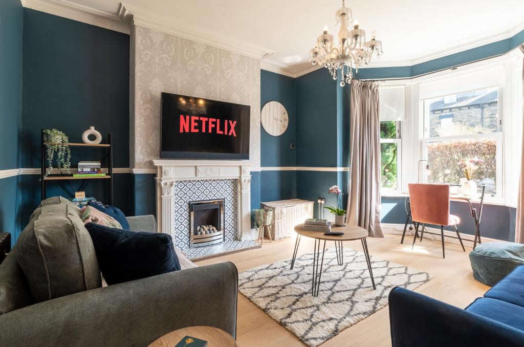 a living room with blue walls and a fireplace at Beautiful 3 Bedroom Townhouse in Harrogate