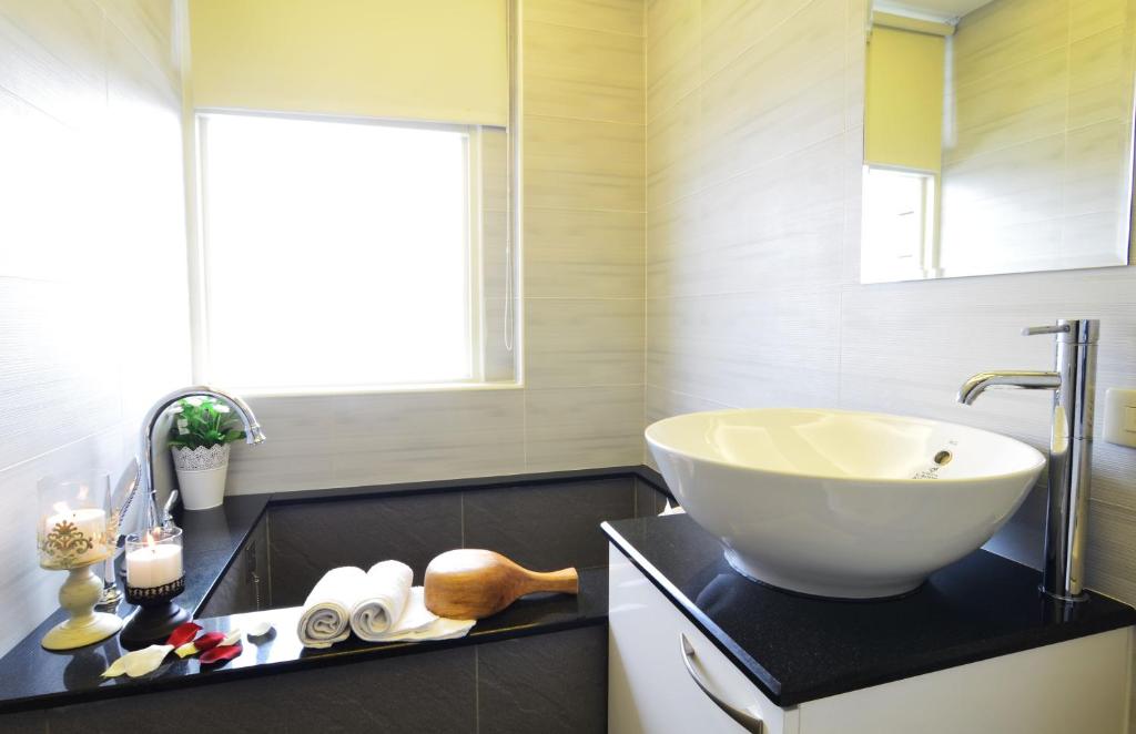 a bathroom with a large white bowl sink on a black counter at Yunju House in Jiaoxi