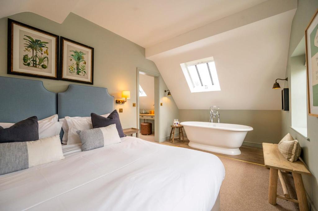 a bedroom with a large white bed and a bath tub at The Bottle & Glass Inn - Book All 3 Rooms in Henley on Thames