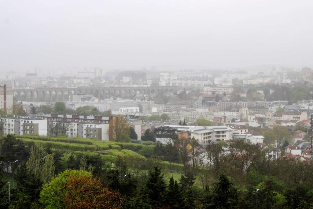 uitzicht op een stad met gebouwen en bomen bij Brand new studio with an open view on Paris in Arcueil