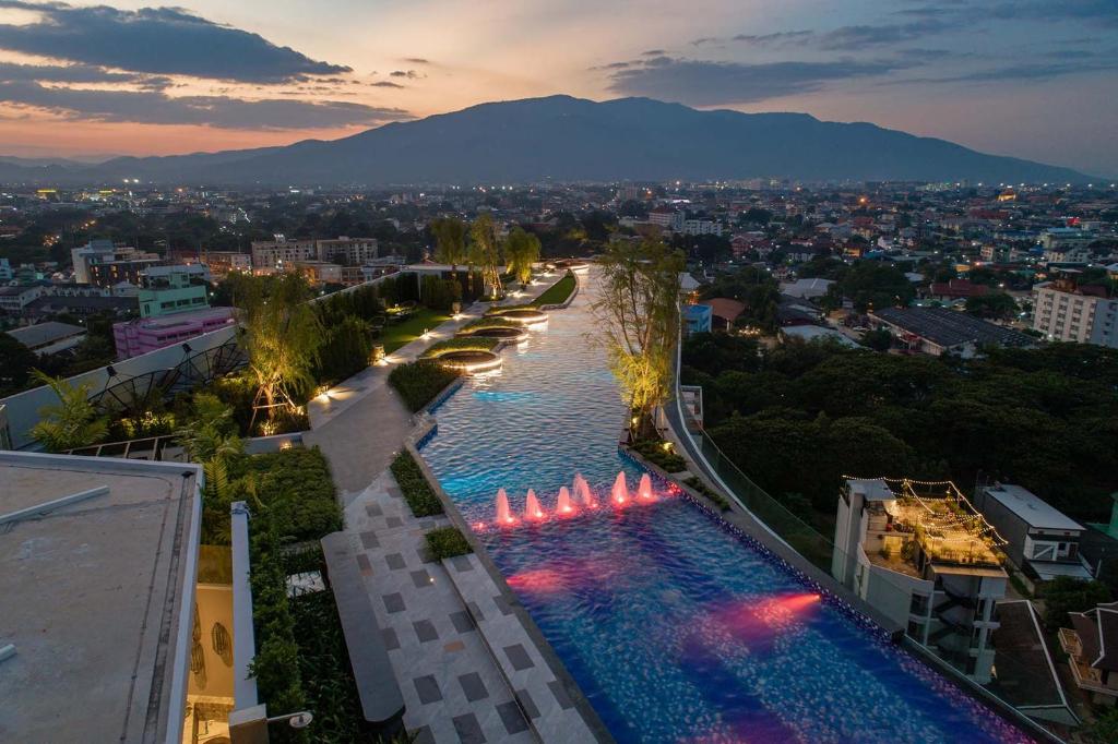 a large pool with lights in a city at night at Amazing View The Astra Sky River, Chiang Mai in Chiang Mai