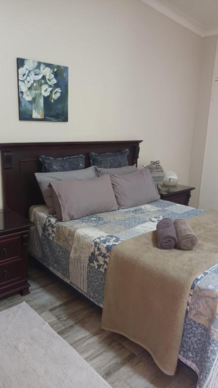 um quarto com uma cama grande com almofadas em Lushof Guesthouse em Witbank