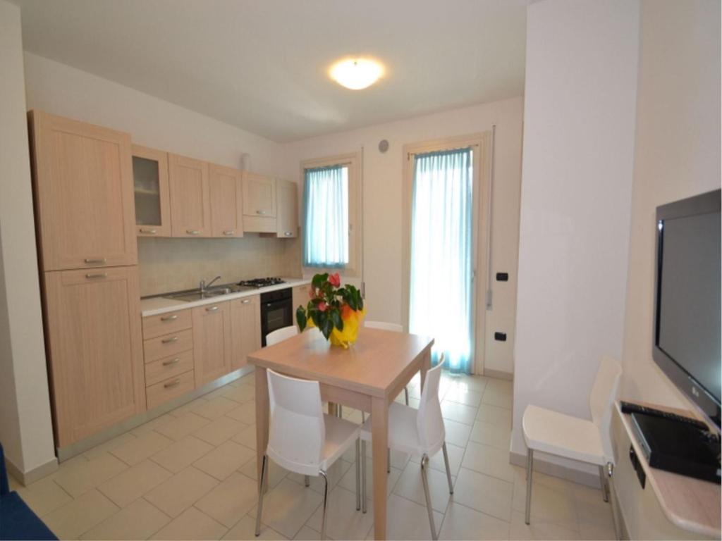 a kitchen with a table with a vase of flowers on it at Modern and bright apartment - Beahost Rentals in Rosolina Mare