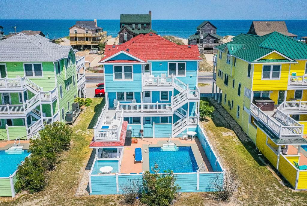an aerial view of a row of colorful houses at Jockey's Ridge Haven - NH MP 13, Pool-Open Now for 2026, Cabana, Hot Tub, Pets OK, YR Flex Stays in Nags Head