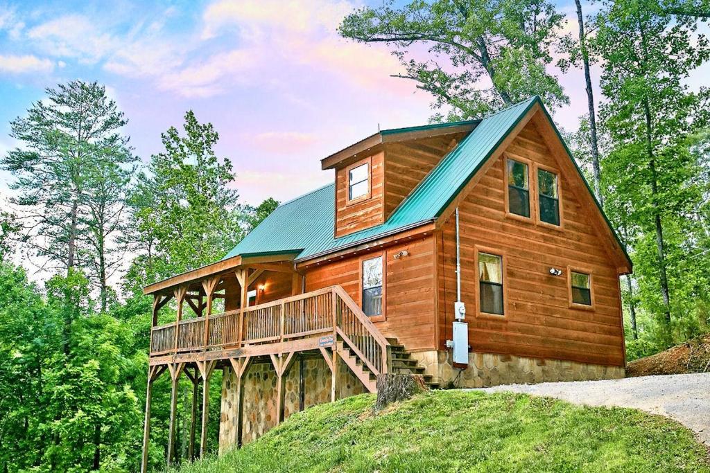 une cabine dans les bois avec un toit vert dans l'établissement A Bear's Eye View #251, à Sevierville