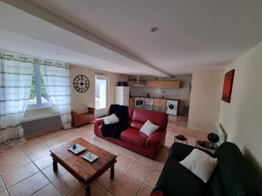 un salon avec un canapé rouge et une table dans l'établissement Merlinite - 4 couchages, à Archigny