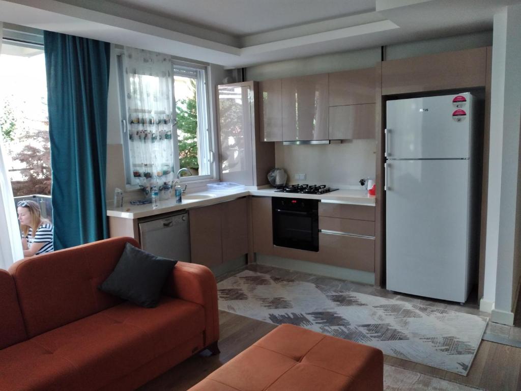 a kitchen with a couch and a white refrigerator at Şehir merkezinde iki odalı daire in Antalya