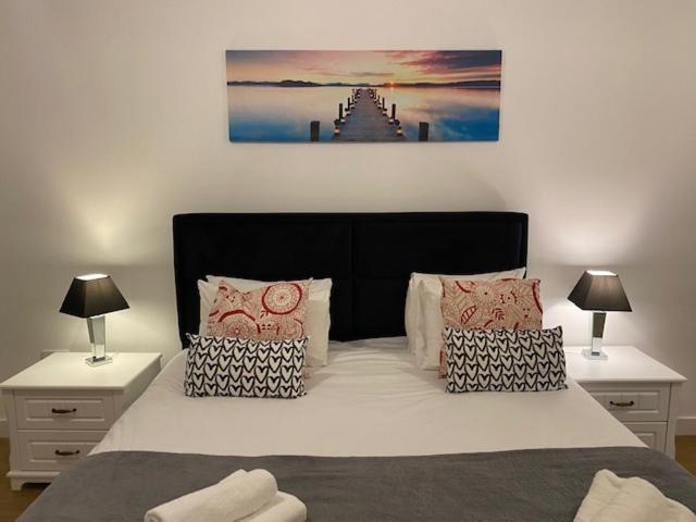 een slaapkamer met een groot bed met 2 nachtkastjes bij Berks Luxury Serviced Apartments RWH 76 1 Bedroom, 1 super king bed, free parking, gym & wifi in Bracknell