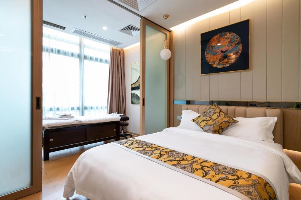 Un dormitorio con una gran cama blanca y una ventana en Cloud Land Apartment 翡翠华庭 en Guangzhou