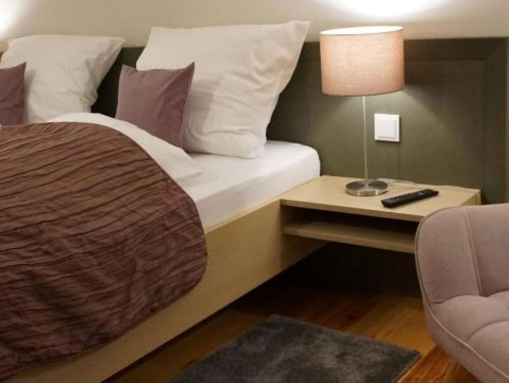 um quarto com uma cama e uma mesa com um candeeiro em Gasthof Weißes Ross em Iphofen