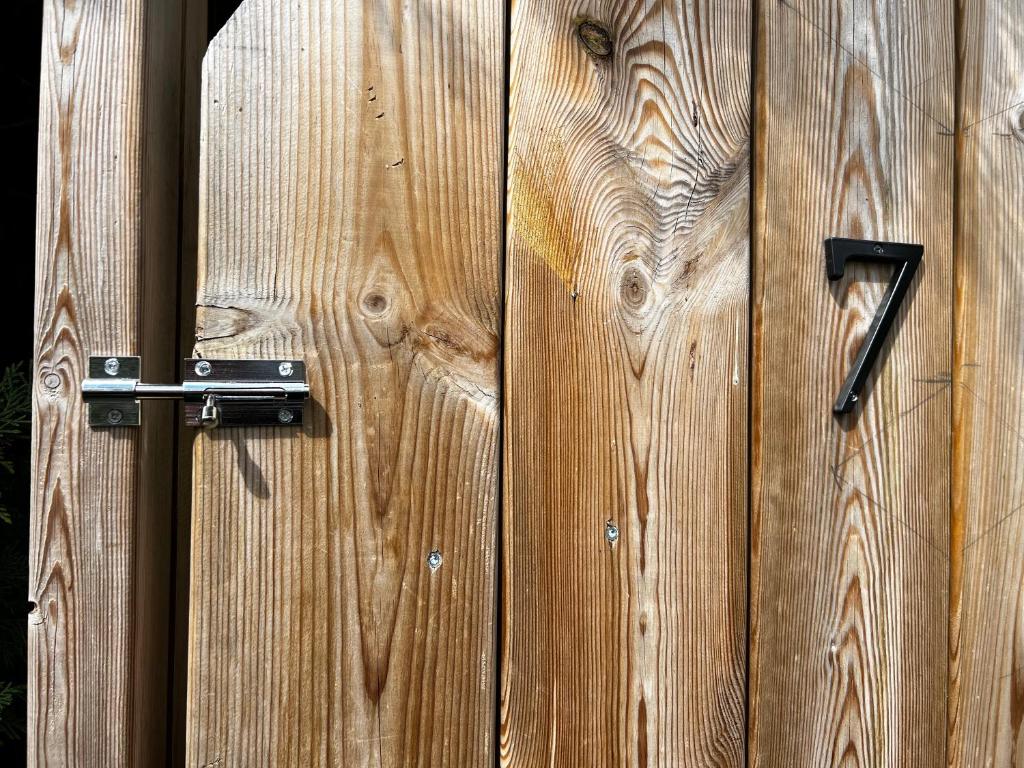 a wooden fence with a black door knocker on it at Embrun - Appartement 4&#47;6 personnes avec extérieurs in Embrun
