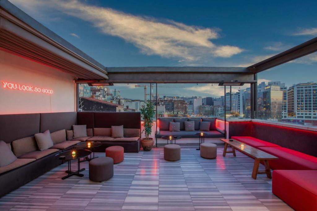 a rooftop patio with couches and tables on a building at Wabi Sabi Hostel Istanbul in Istanbul