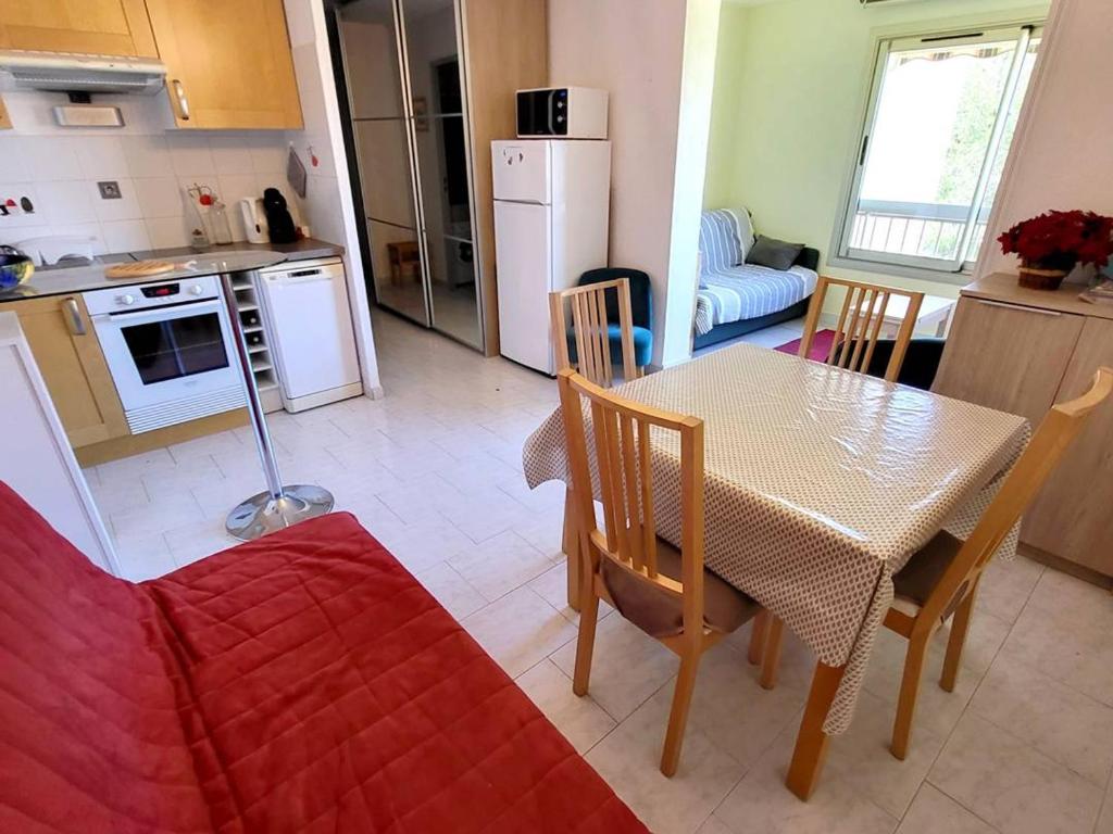 une cuisine et une salle à manger avec une table et des chaises dans l'établissement T2 cosy avec piscine, tennis, parking - 200m des plages - FR-1-316-245, à Six-Fours-les-Plages