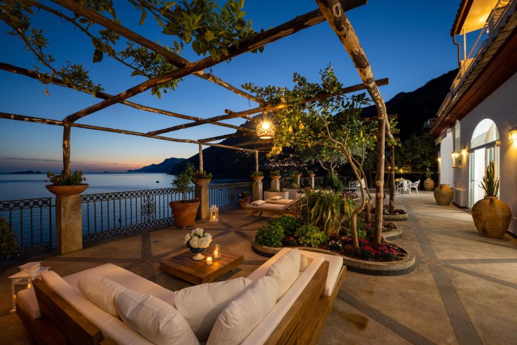eine Terrasse mit Sofas und Blick auf das Wasser in der Unterkunft YourHome - Villa Aldo Marino in Positano