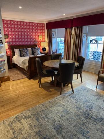 Schlafzimmer mit einem Bett, einem Tisch und Stühlen in der Unterkunft The Captains Quarters in Berwick-Upon-Tweed