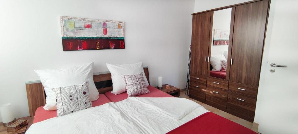 1 dormitorio con 1 cama con sábanas y almohadas blancas en Haus-am-Waldbad-Whg-12-7, en Cuxhaven
