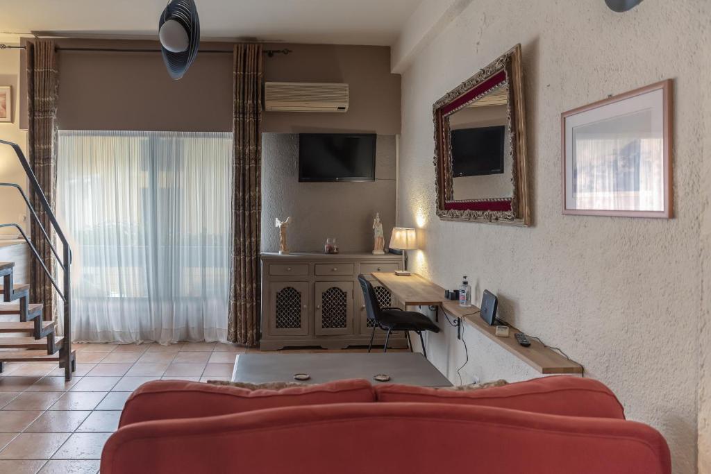 een woonkamer met een rode bank en een bureau bij The heart of Plaka in Athene