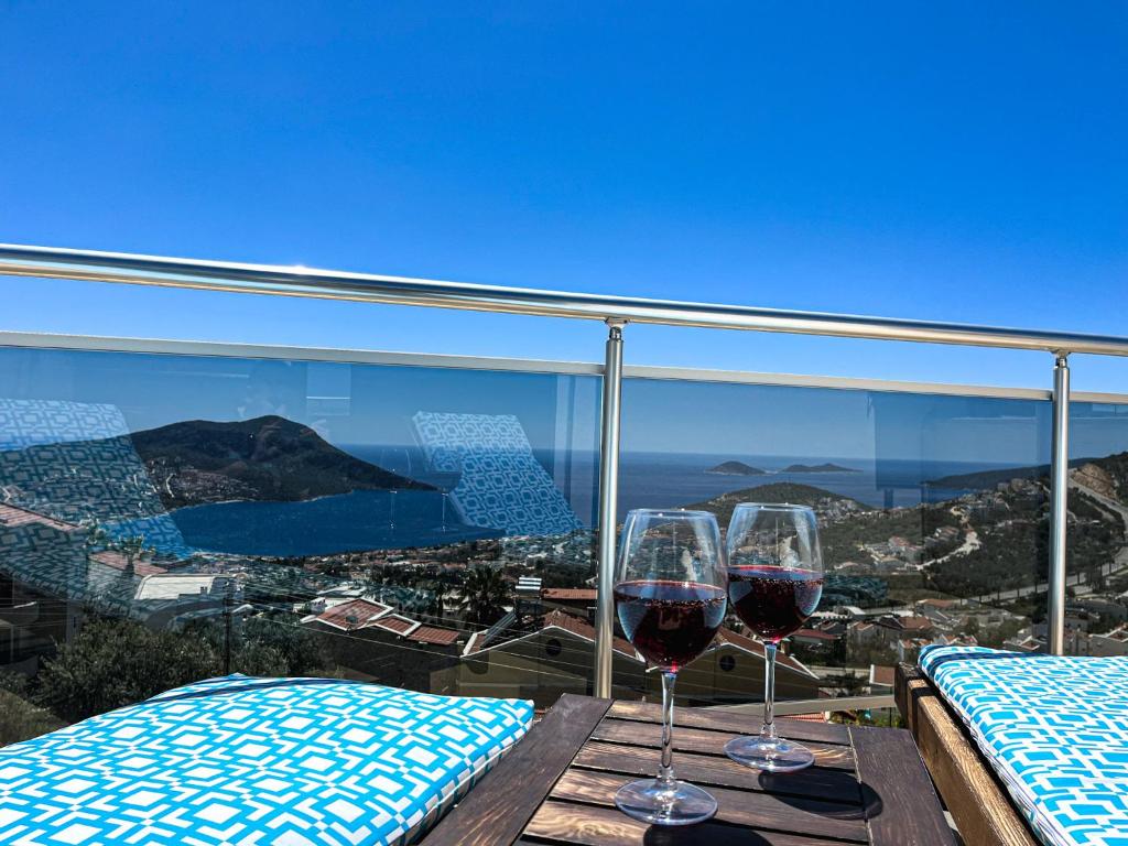 two glasses of wine sitting on a table on a balcony at Apollon Apartment in Kalkan