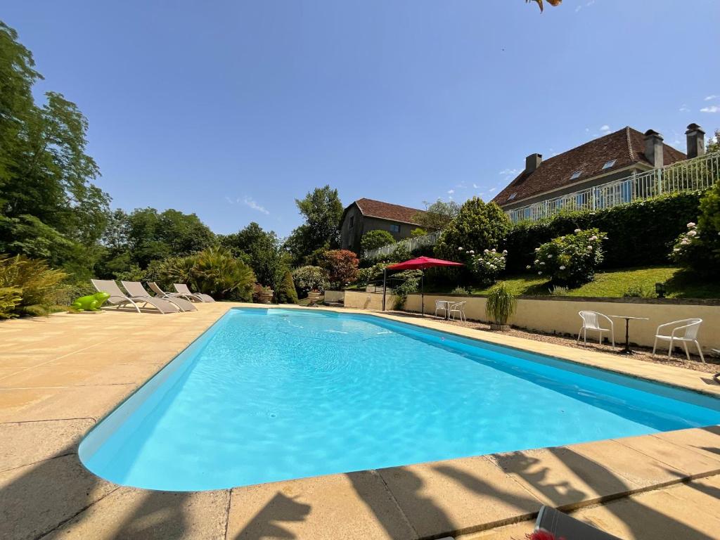 a large swimming pool with blue water in a yard at Domaine de la Carrère in Arthez-de-Béarn