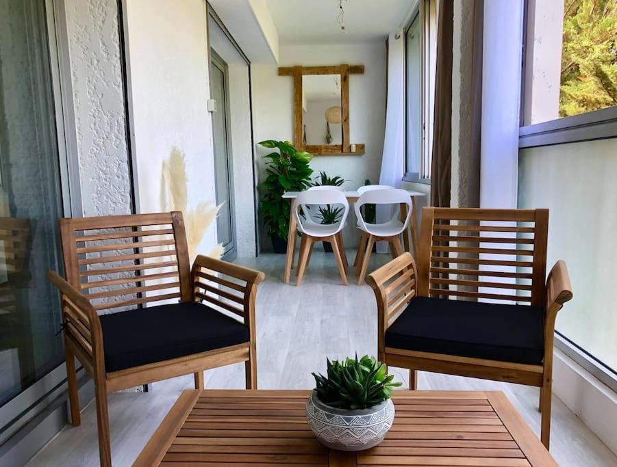 une terrasse couverte avec 2 chaises et une table. dans l'établissement Appartement calme et chaleureux, à Six-Fours-les-Plages
