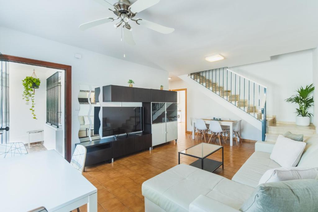salon z białą kanapą i stołem w obiekcie Dúplex junto a la playa w mieście Sanlúcar de Barrameda