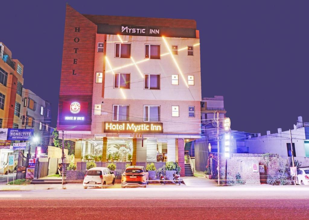 a hotel with cars parked in front of a building at Hotel Mystic Inn in Jaipur